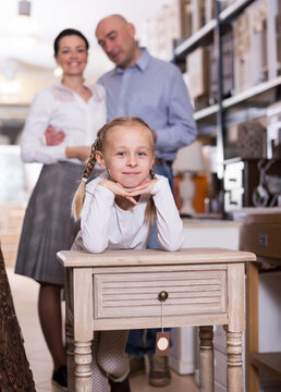 Smilling girl whois stading with curbstone in furniture shop