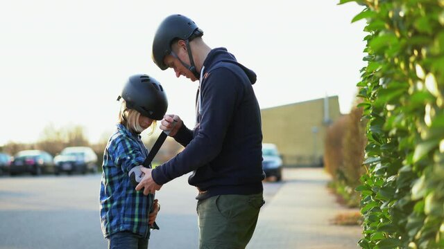 father and son skateboarding on a suburban street.