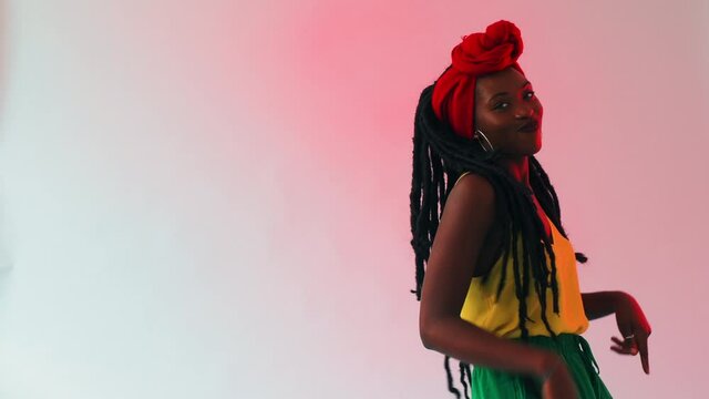A young black woman dancing freely, moving her body to a strong beat. 
