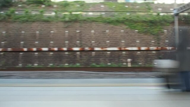 Close up fast moving train with motion blur at train platform. Video for mass transportation, travel and city life concept.