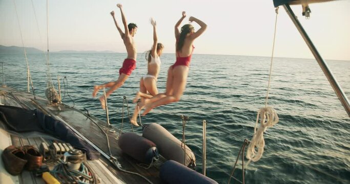 Group of young friends enjoying trip on a sailboat in the Ligurian Sea.