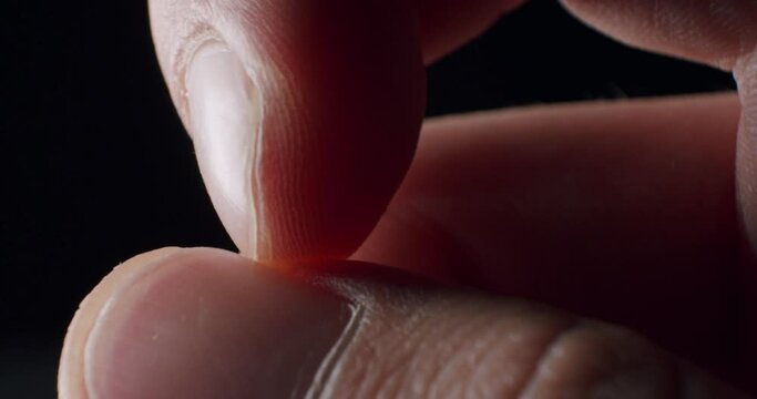 Extreme Closeup of index finger scratching thumbnail in a nervous manner being pressed