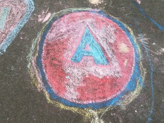 a blue and red circle with the letter A made from chalk