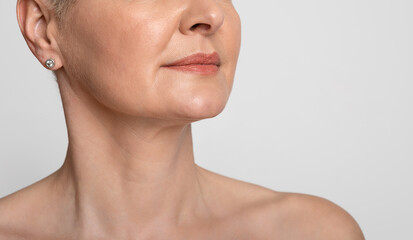 Skin Lifting. Mature woman with smooth skin over light background, cropped image - Powered by Adobe