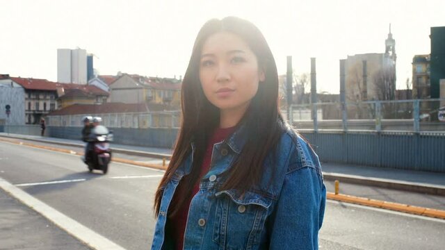 Young woman in denim jacket posing and laughing.