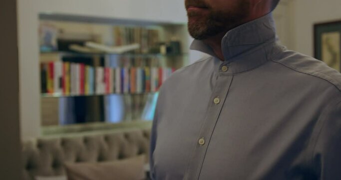 Close up of man getting dressed in the morning, putting on a red tie.