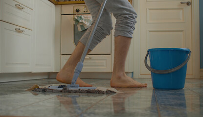 Legs of a man washing the floor