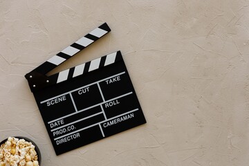 Filmmaking concept. Movie Clapperboard. Cinema begins with movie clappers.Movie clapper board on a light textural background and popcorn and popcorn.