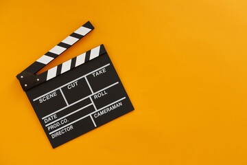 Fototapeta na wymiar Filmmaking concept. Movie Clapperboard. Cinema begins with movie clappers. Place for your text. Yellow background.