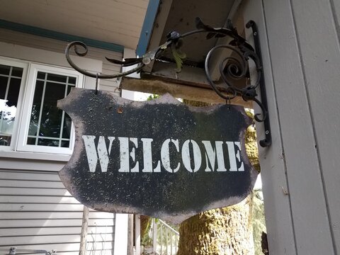 Weathered Black Metal Welcome Sign Hanging On Wall