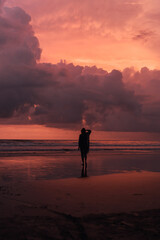 Fototapeta premium social distancing on the beach , pink and orange amazing cloudy sky , beautiful sunset , Bali Indonesia , solo outdoor walking 