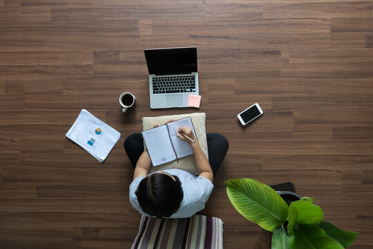 Top View Work From Home Ideas Concept. Women Working Laptop Computer On Wooden Floor