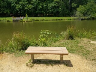 Fototapeta na wymiar bench overlooking a pond