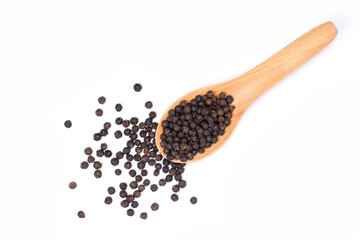 Closeup black pepper seeds or peppercorns ( dried seeds of piper nigrum) in wooden spoon isolated on white background. top view. Flat lay.