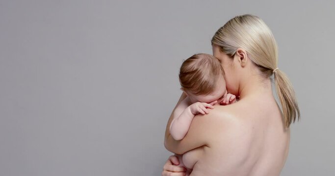 SLO MO MS Shirtless mother holding baby son (6-11 months)