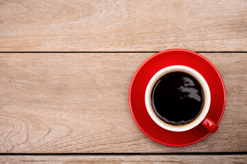 Red cup of coffee isolated on wood table background. Top view. Flat lay. 