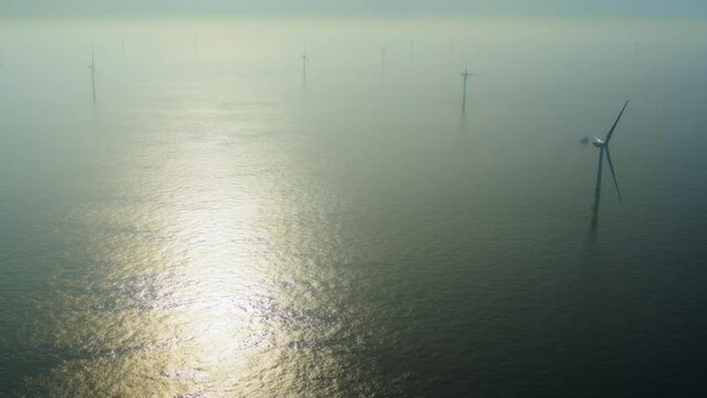AERIAL Wind turbines in calm water at sunset / Domburg, Zeeland, Netherlands