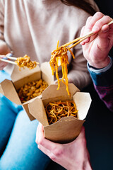 young people eating noodles indoor
