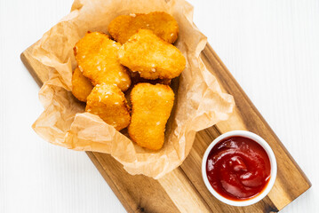 chicken nuggets with ketchup on the wooden board