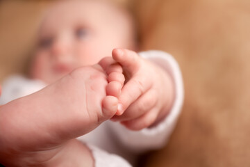 Baby reaching with its hand for its toes