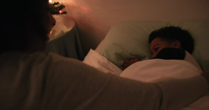 MS HANDHELD Mother assisting son (6-7) in bedroom with Christmas tree / Dinton, Wiltshire, UK