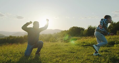 Father and son playing football, Father's day, Playful Man teaching Boy rugby outdoors in sunny day at public park. Family sports weekend. 4K video.
 - Powered by Adobe