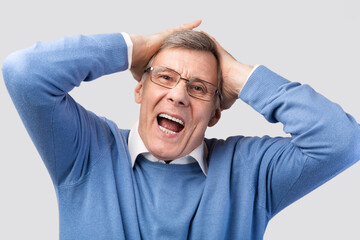 Emotional Senior Man Shouting Touching Head Posing On Gray Background