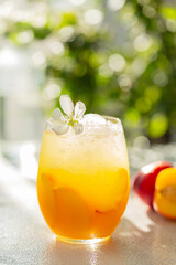 Peach cocktail or tea with ice. Refreshing iced tea with ripe peaches, selective focus. Close up