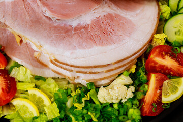 Sliced ham with vegetables. Close up.