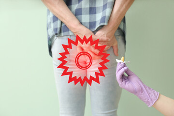 Man suffering from hemorrhoids and doctor's hand with suppository on color background