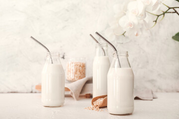Bottles of tasty oat milk on table