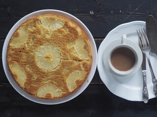 Sponge cake with pineapple on a dark wooden table.Home cooking.