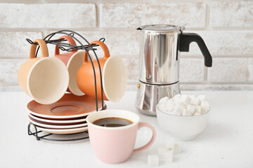 Holder with cups and saucers on kitchen table