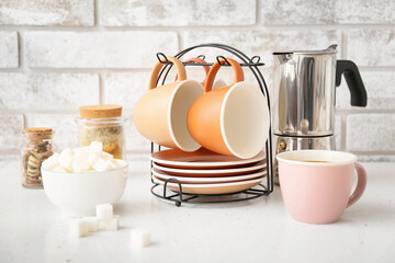 Holder with cups and saucers on kitchen table