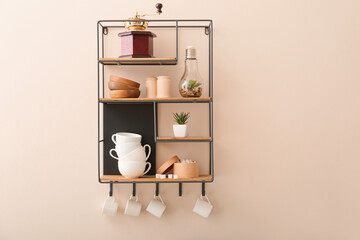 Shelf with cups on light wall