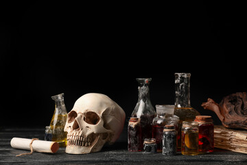 Potions, human skull and old book on alchemist's table