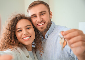 Happy young couple with key in their new flat