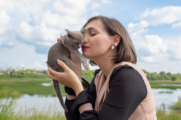 The pet owner girl is playing with her cat