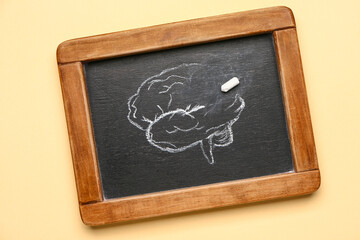 Chalkboard with drawing of human brain on color background. Concept of dementia