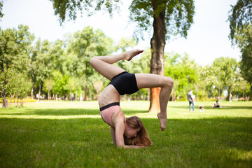 Obraz na płótnie Canvas Girl is practicing yoga in the park. Healthy lifestyle. 
