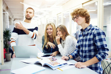 Fototapeta premium Smiling handsome young international students resting after lesson 