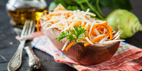 salad from a kohlrabi with carrots in a bowl on a table. selective focus. copy space.