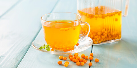 Vitaminic healthy sea buckthorn tea  with fresh raw sea buckthorn berries, selective focus, copy space