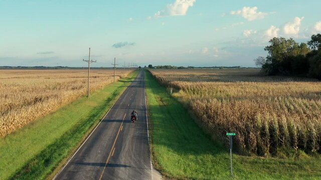 AERIAL WS Man riding motorcycle on rural road  / Plattsburg, Missouri, USA