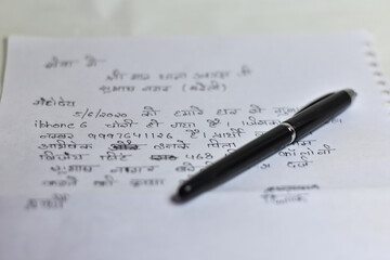 boy writing a application on a white note book paper on a table, Writing Application   