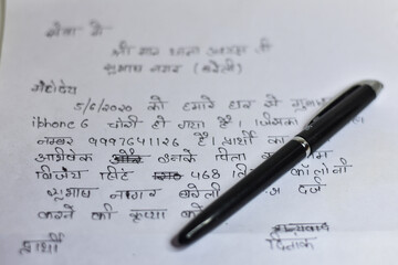 boy writing a application on a white note book paper on a table, Writing Application   