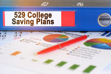 On the table are pie charts, a pen and a folder with the inscription - 529 College Saving Plans.