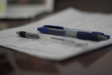 Penciles and pens on a white paper.