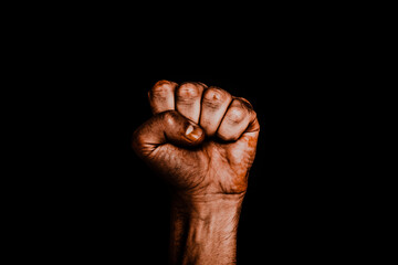 Male black fist on a black background. Aggressiveness, masculinity, the concept of challenge