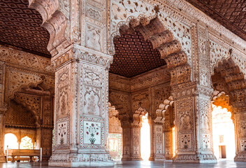 Architectural details and traditional patterns on white marble arches and pillars inside the famous historic monument of India. Hall of private audience of Mughal emperor at Red Fort Delhi, India.